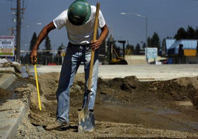 
Bridge builder Tim Petersen measures the depth of the road bed on a section of Government Way connected to the bridge in Coeur d'Alene on Friday. 
 (Holly Pickett / The Spokesman-Review)