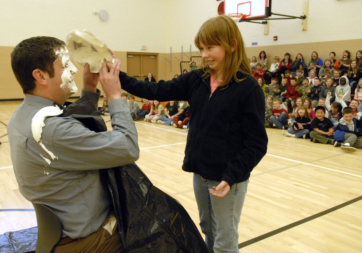 Orchard Center second-grader Tyler Clark smushes a pie into Principal Travis Peterson face. (J. Rayniak / The Spokesman-Review)