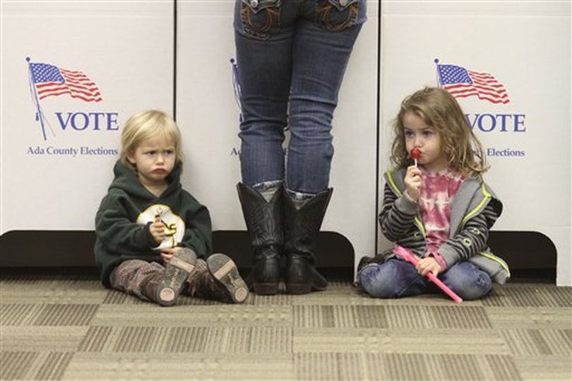 Rebelann Barfield, left, and her sister November, sit as their mother Khara casts her vote in the general election on Tuesday, Nov. 2, 2010 in Star, Idaho. (AP Photo/Charlie Litchfield) (AP Photo / Charlie Litchfield)