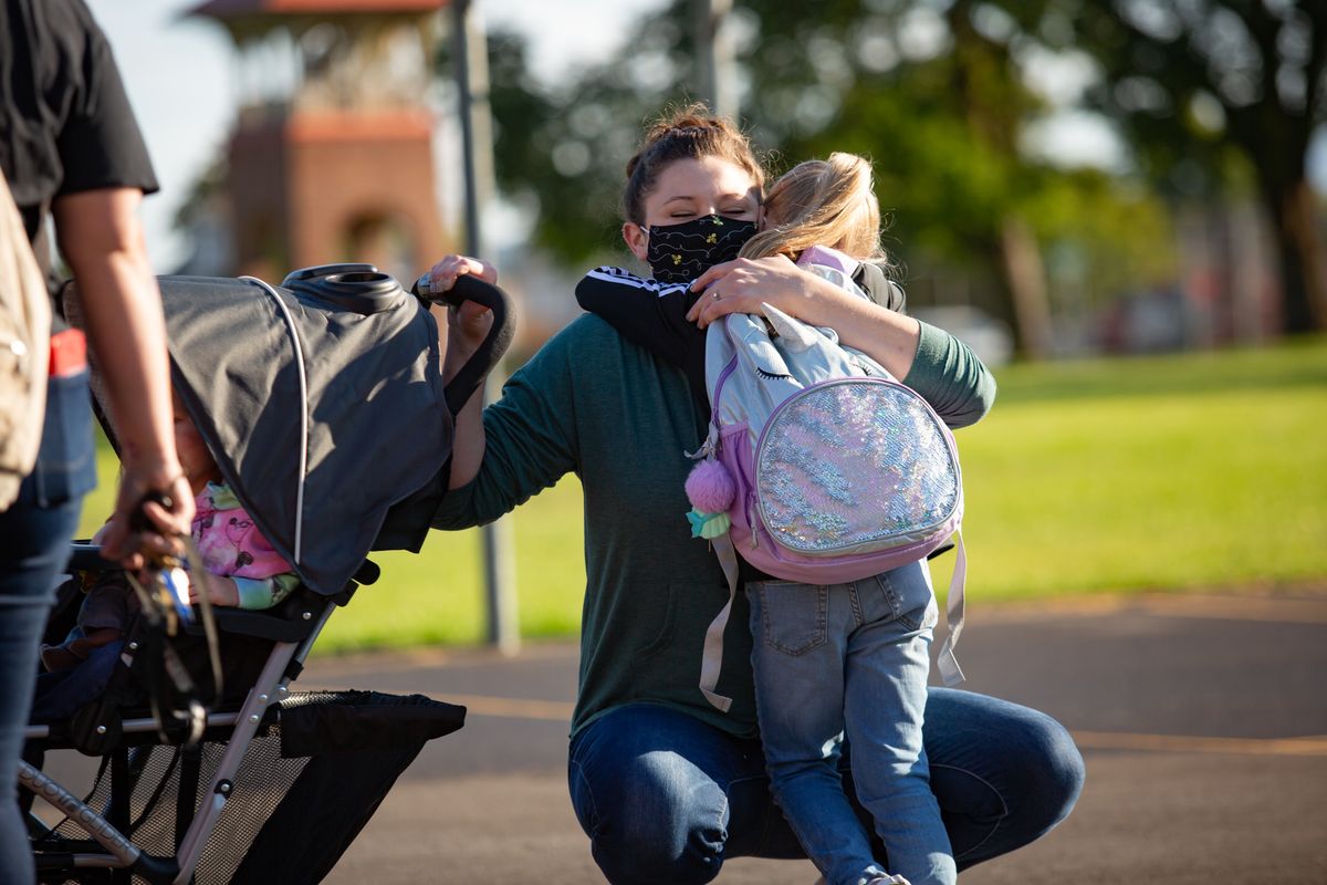 Kodi Heyn says goodbye and hugs her daughter, first-grader Hazel Heyn, on the first day of the 2021-22 school year Thursday at Regal Elementary School. Hazel was home-schooled last year, so this marks the first time that she is in a public school setting among peers.  (Libby Kamrowski/ THE SPOKESMAN-REVIEW)