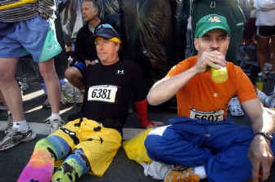 
Wayne Foster, right, gulps a sports drink while waiting at the front of the yellow start with Ron Giachetti, left, at Bloomsday. Foster was first at the starting line at 4:30 a.m. and Giachetti arrived at 6 a.m. 
 (Holly Pickett / The Spokesman-Review)