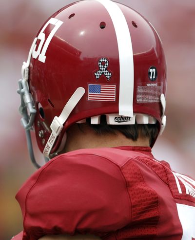 Alabama Crimson Tide long snapper Carson Tinker, along with his teammates, wear a houndstooth ribbon to remember the April 27, 2011, tornado, and the number 77 for fellow teammate Aaron Douglass, who died last May. (Associated Press)