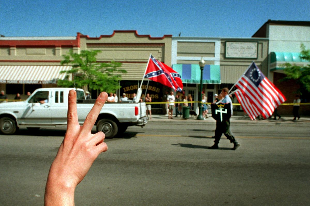 FILE- In this 1999 file photo, a protester flashes the peace sign at the Aryan Nations parade as the white separatists