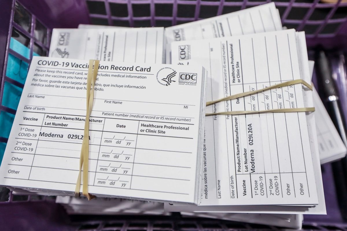 A stack of vaccine cards waits to be handed out to residents after receiving Moderna COVID-19 vaccines from the Oakland County Health Division on Jan. 23 in Novi, Mich. (Tribune News Service)