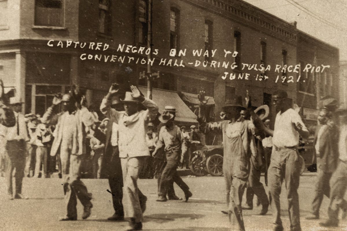 In this photo provided by the Department of Special Collections, McFarlin Library, The University of Tulsa, a group of Black men are marched past the corner of 2nd and Main Streets in Tulsa, Okla., under armed guard during the Tulsa Race Massacre on June 1, 1921. On May 31, 1921, carloads of Black residents, some of them armed, rushed to the sheriff