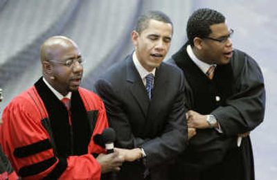 
Sen. Barack Obama  links arms with Rev. Raphael Warnock, left, and associate pastor Shanan Jones  during a church service at Ebenezer Baptist Church on Sunday in Atlanta.
 (Associated Press / The Spokesman-Review)