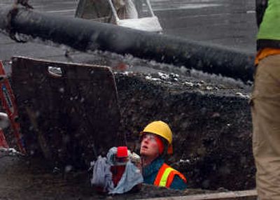 
Scott Ives of the Spokane Water Department watches as a length of pipe is lowered into a trench across Maple Street on Friday. Crews are working to replace water mains prior to the  the Maple/Ash corridor reconstruction. 
 (Jesse Tinsley / The Spokesman-Review)