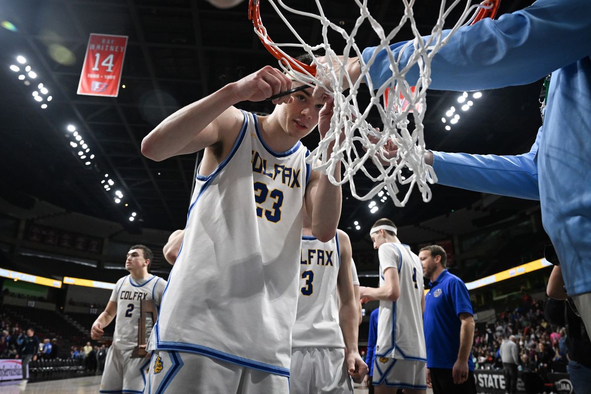 Adrik Jenkin, the son of coach Reece Jenkin, who died of cancer the week before the state tournament, cuts down the net after the Colfax boys won their 2B championship game over Adna on Saturday at the State B tournament at the Spokane Arena. The Colfax Bulldogs beat the Adna Pirates to go undefeated for the year and win the state title.  (Jesse Tinsley/THE SPOKESMAN-REVI)
