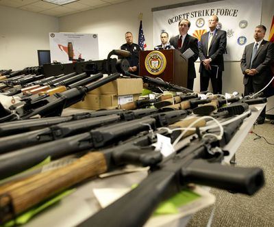 Dennis Burke, U.S. attorney for Arizona, speaks behind a cache of seized weapons Tuesday in Phoenix that were intended for a Mexican drug cartel.  (Associated Press)