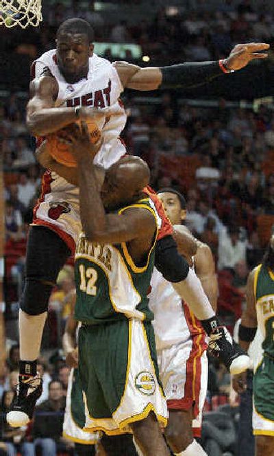 
Miami's Dwyane Wade, top, fouls  Sonics' Damien Wilkins. 
 (Associated Press / The Spokesman-Review)