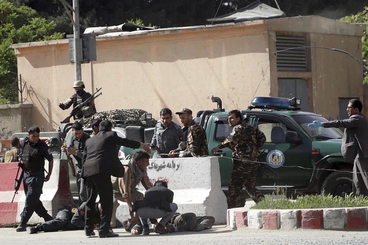 Security officers and rescuers help victims in explosion in Kabul, Afghanistan, Monday, April 30, 2018. The double explosions targeted central Kabul on Monday morning, killing people, including a journalist, and wounding a dozen, authorities said. (Massoud Hossaini / AP)
