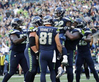 Seattle Seahawks running back Chris Carson (32) is lifted by offensive guard D.J. Fluker after Carson scored a touchdown against the Dallas Cowboys during the second half , Sunday, Sept. 23, 2018, in Seattle. (John Froschauer / Associated Press)