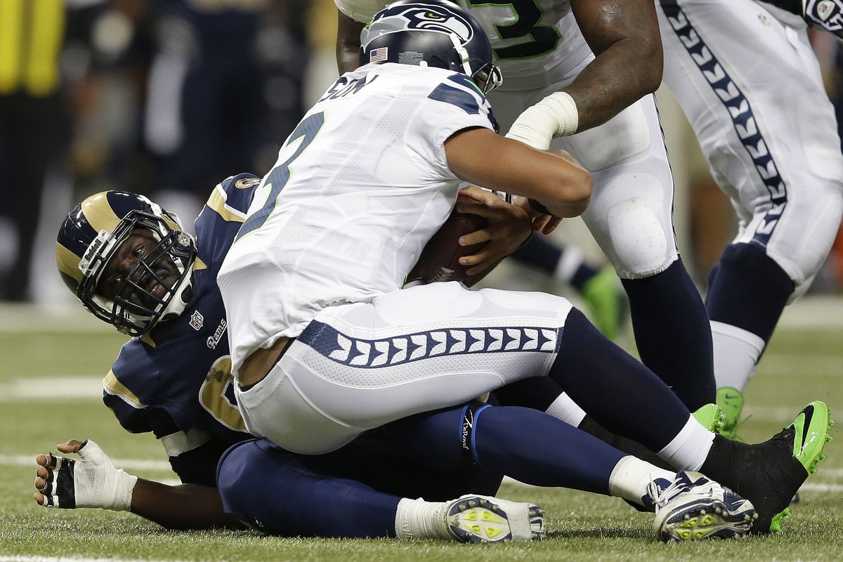 Defensive end William Hayes, left, and the St. Louis Rams made it rough on Seattle Seahawks quarterback Russell Wilson in October. (Associated Press)