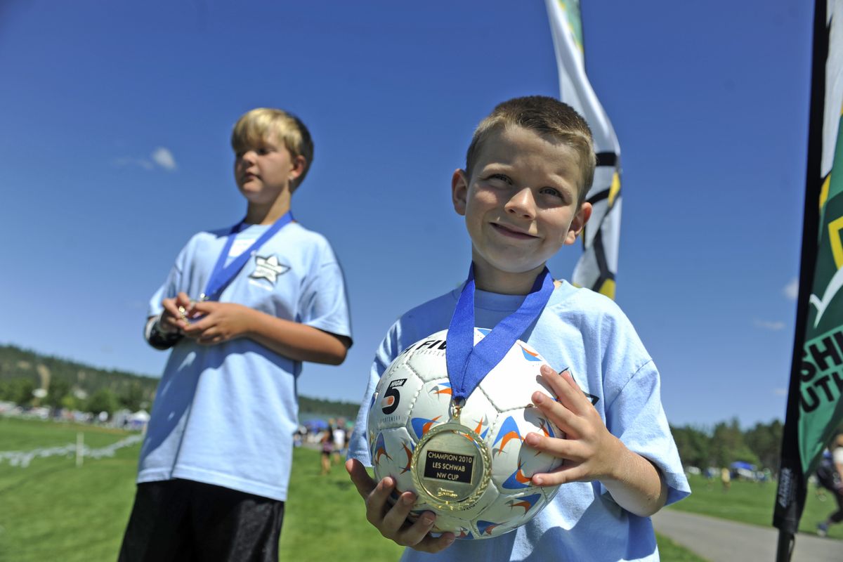 Colin Kelly, 7, right, and Zachary Archer, 10, show off their medals at the TOPSoccer Jamboree last Saturday at Plantes Ferry Park in Spokane Valley. TOPSoccer is a program for children and adults with mental and physical disabilities.  (Jesse Tinsley)