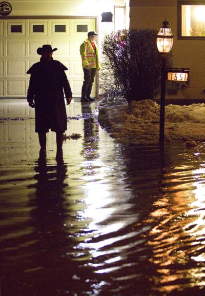 Dana Rand, right, from the Moscow Street Department talks to residents of Hillcrest Drive to find out who will need help sandbagging around their homes after Paradise Creek began flooding on Thursday, March 9, 2017, in Moscow, Idaho. (Geoff Crimmins / Moscow-Pullman Daily News via AP)