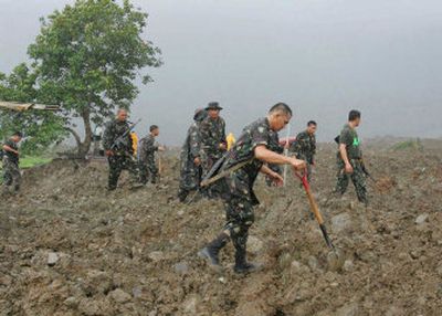 
Filipino soldiers search for victims buried in tons of mud Saturday,  following a massive landslide that buried the village of Guinsaugon. Officials estimate the number of dead to be 1,800. 
 (Associated Press / The Spokesman-Review)