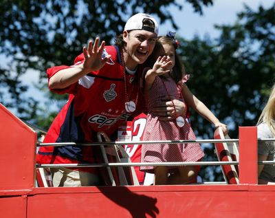 Washington Capitals right wing T.J. Oshie waves while holding his daughter Lyla Oshie during a Stanley Cup NHL hockey victory parade, Tuesday, June 12, 2018, in Washington. (Alex Brandon / Associated Press)