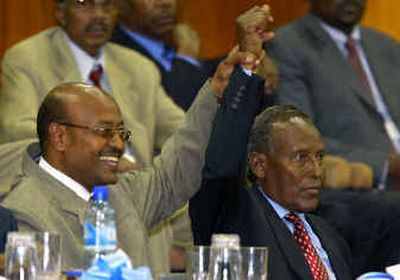
Somali presidential candidate Abdulkadir Sufi, left, holds up the arm of newly-elected Abdullahi Yusuf on Sunday. 
 (Associated Press / The Spokesman-Review)