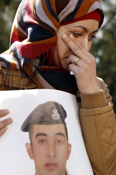 Anwar al-Tarawneh, the wife of Jordanian pilot Lt. Muath al-Kaseasbeh, holds a poster of him as she weeps during a protest Tuesday in Amman, Jordan. (Associated Press)
