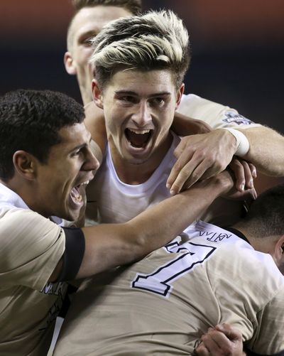 FILE - In this Friday, Dec. 9, 2016, photo, Wake Forest players pile on teammate Ian Harkes, center, after he scored the winning goal during the second overtime against Denver at the NCAA soccer men's College Cup semifinal in Houston. (Yi-Chin Lee / Associated Press)