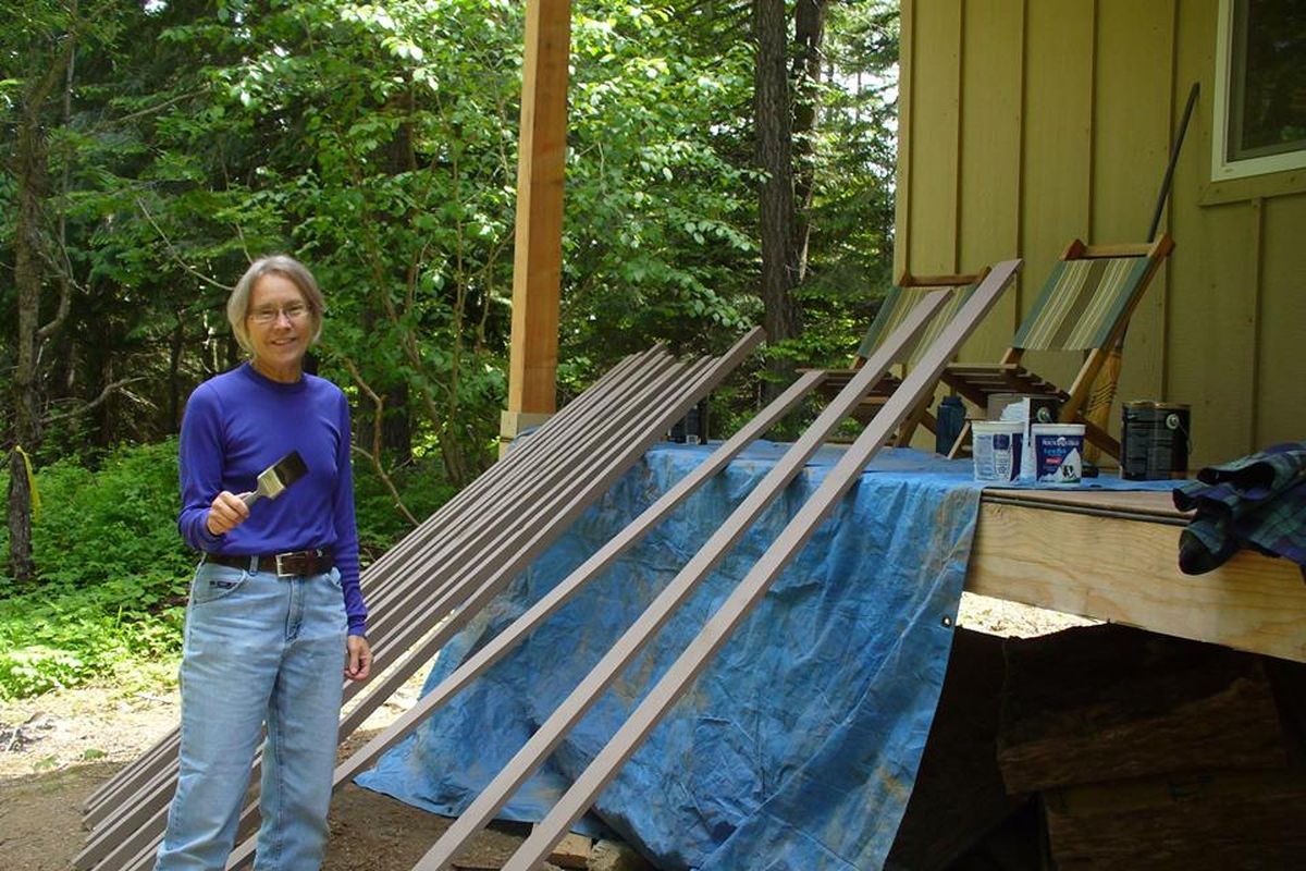 Nora Searing paints stair rails at the new snowshoers hut being finished in the summer of 2014 at Mount Spokane State Park. (Cris Currie)
