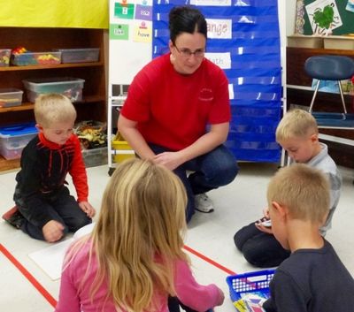 Challis Elementary School teacher Lori Gregory works with kindergarten students. Some educators are concerned the long days associated with the four-day calendar are hard on the youngest students. (Photo by Clark Corbin, Idaho Education News.)