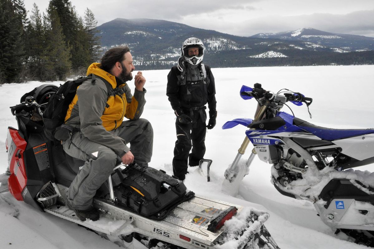 Merlin Walraven on the snowmobile and Ryan Porter with a snow cycle take a riding break on the shore of Priest Lake near Beaver Creek Campground. (Rich Landers / The Spokesman-Review)