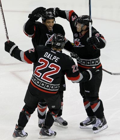 Carolina Hurricanes Zac Dalpe and Tim Brent, right, congratulate Anthony Stewart on his third-period goal against Boston. (Associated Press)