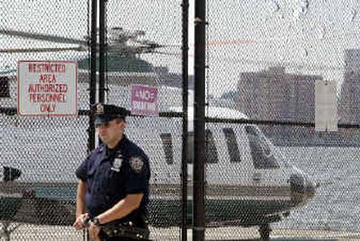 
A helicopter sitting at a New York heliport prepares to take off as an NYPD officer stands guard Monday. American law-enforcement agencies have warned that al Qaeda might use helicopters and limousines in terror attacks.
 (Associated Press / The Spokesman-Review)