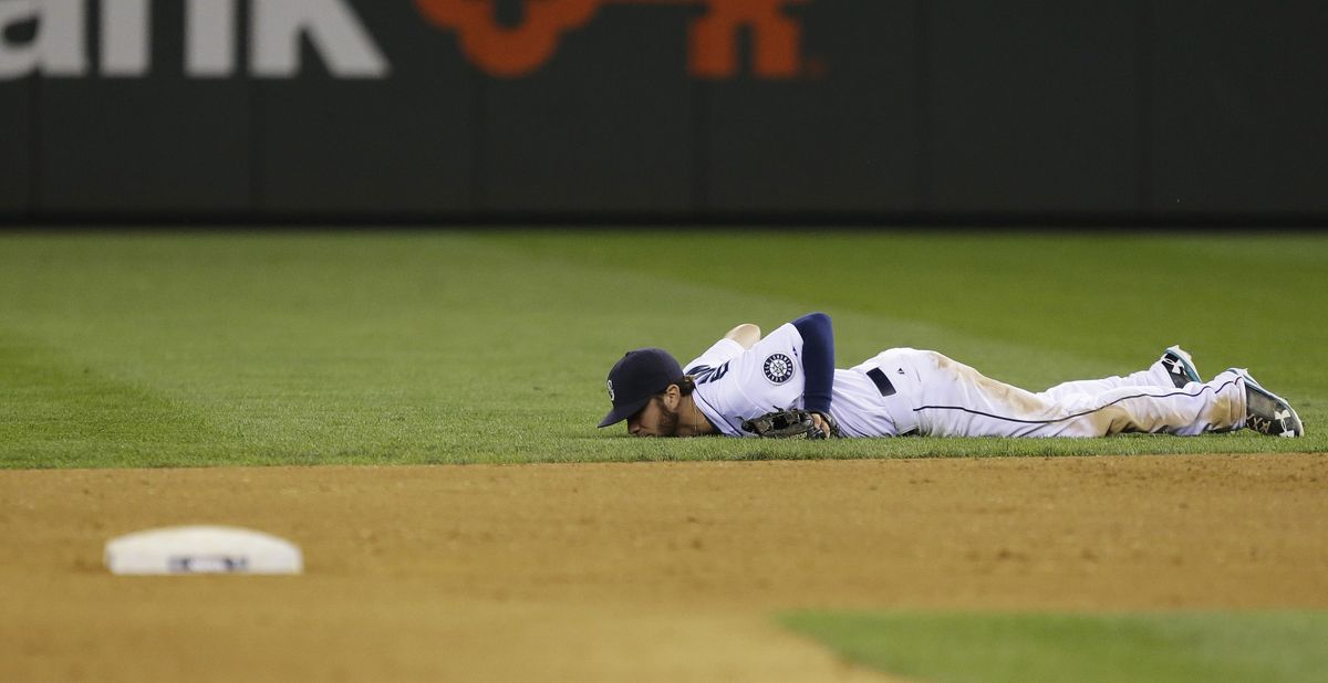Mariners second baseman Nick Franklin lies on the the grass after he got a glove on a single hit by Boston’s David Ortiz. (Associated Press)