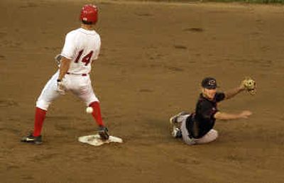 
Spokane's Ben Harrison scoots into second base with a sixth-inning double as the ball gets away from Yakima second baseman Erik Schindewolf on Tuesday night at Avista Stadium. 
 (Colin Mulvany / The Spokesman-Review)