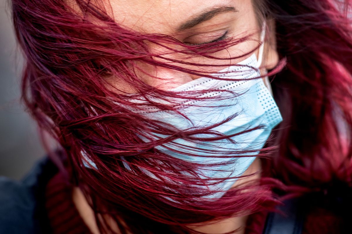 Courtney Hughes braces against the swirling winds as she waits to board a bus at the STA Plaza, Tuesday, Oct. 13, 2020 in downtown Spokane, Wash.  (Colin Mulvany/THE SPOKESMAN-REVIEW)