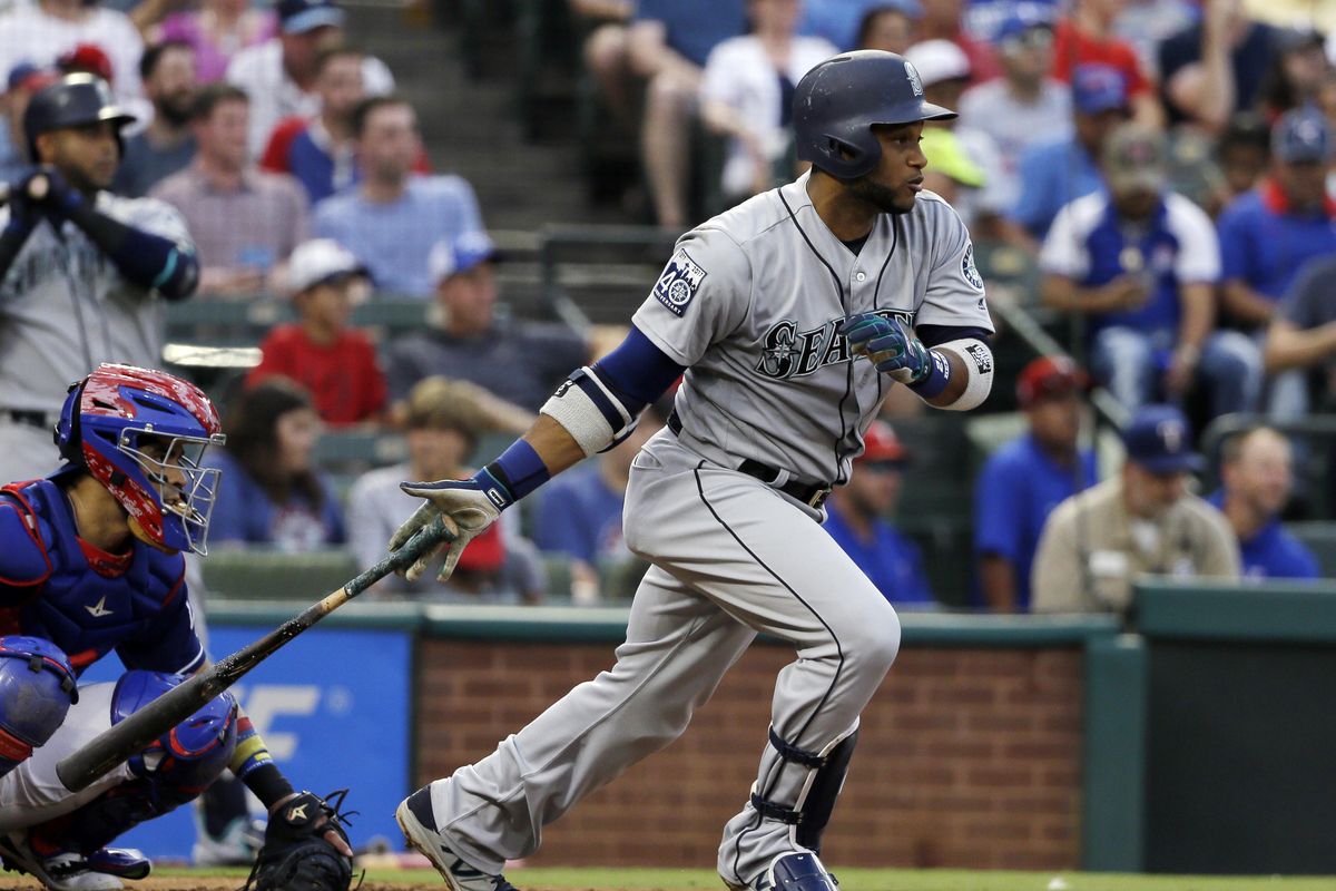 Seattle Mariners' Robinson Cano follows through on a single up the middle as Texas Rangers' Robinson Chirinos watches during the third inning of a baseball game, Wednesday, Aug. 2, 2017, in Arlington, Texas. (Tony Gutierrez / Associated Press)