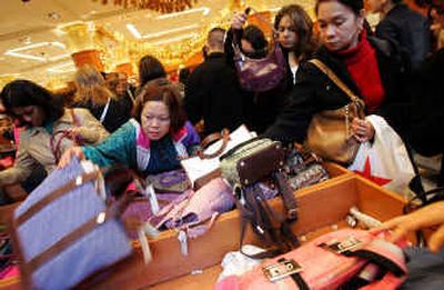 
Shoppers sort through the handbag selection at Macy's in San Francisco on Friday. Shoppers swarmed the nation's stores and malls Friday. 
 (Associated Press photos / The Spokesman-Review)