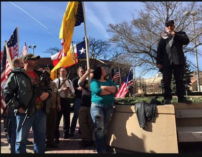 Gun-rights activist Anthony Bosworth addresses a crowd of demonstrators defying a federal firearms ban outside the U.S. Courthouse in downtown Spokane on Friday, March 6, 2015. Bosworth was arrested Feb. 25 outside the courthouse after refusing to leave the plaza while armed with a rifle and pistol. (Jesse Tinsley)