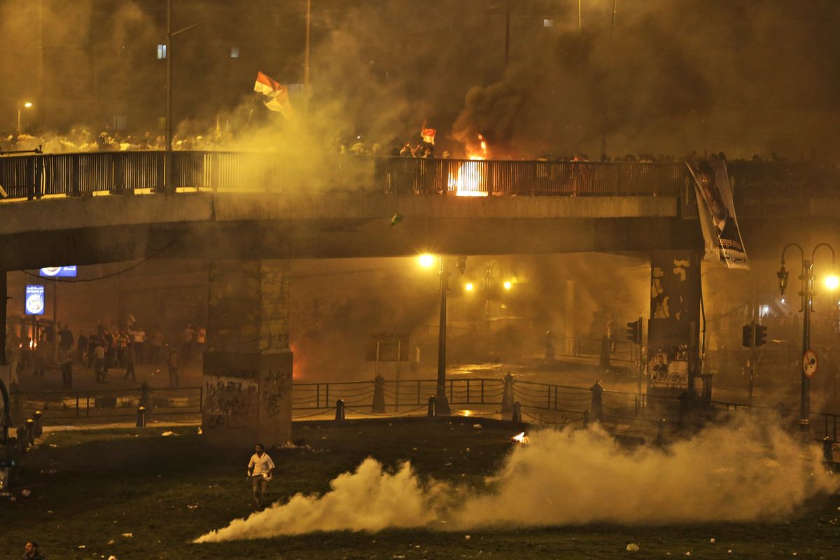 Supporters of ousted President Mohammed Morsi run from tear gas during clashes in downtown Cairo, Egypt, on Monday. Thousands of Morsi supporters held mass rallies and marched in the streets Monday to demand his return to office. (Associated Press)