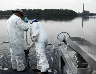 Jon Wager,  of Cetacean Marine, a contractor with the U.S. Environmental Protection Agency, and Mary Beth Ross of the EPA take  water samples from  Morrow Lake in Kalamazoo County, Mich.  (Associated Press)