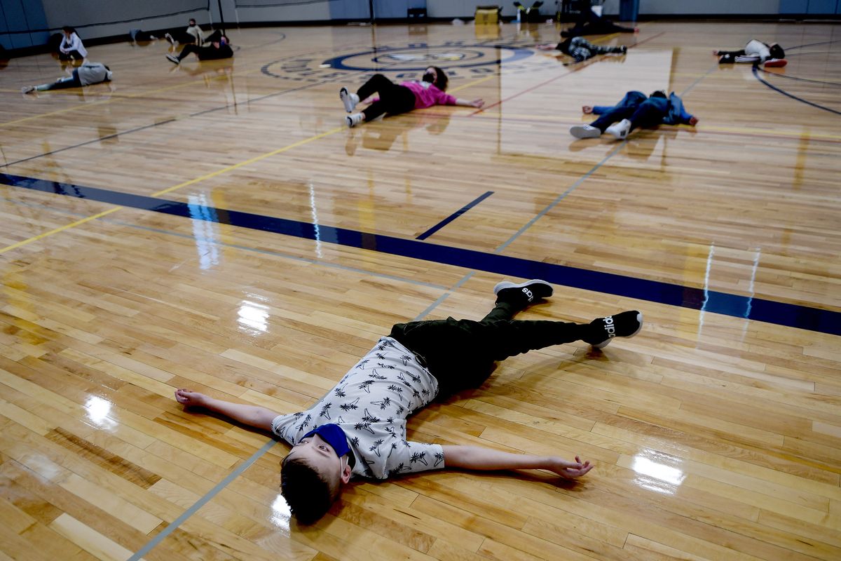 Horizon Middle School sixth-grader Jaxon Payne stretches on the gym floor at the newly remodeled school in Spokane Valley on Friday.  (Kathy Plonka/The Spokesman-Review)