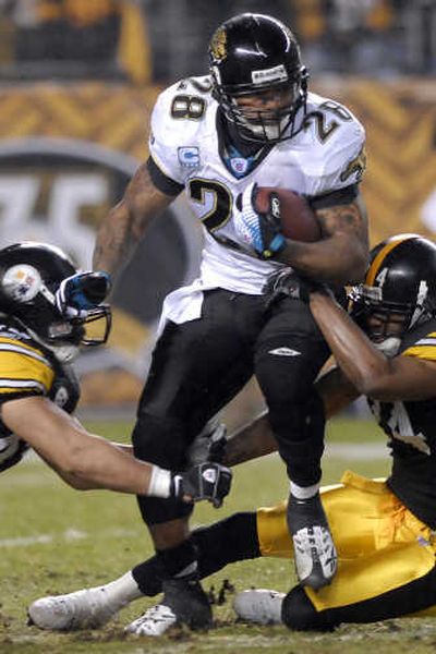 
Steelers defenders Troy Polamalu, left, and Ike Taylor, haul down Jaguars running back Fred Taylor. Associated Press
 (Associated Press / The Spokesman-Review)