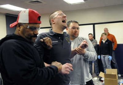 
Pasco Police officer Bill Parramore  experiences the jolt from a Taser while being held up by Lacey Police Department Sgt. Terence Brimmer, left,  and Rob Satake of the Spokane County Sheriff's Office  during training Thursday  at  Spokane Community College. 
 (Dan Pelle / The Spokesman-Review)