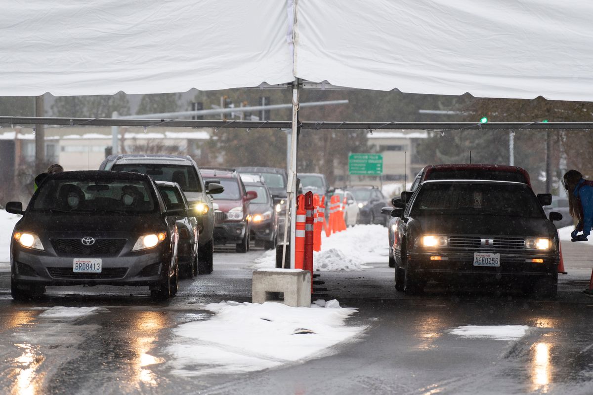 Cars line up and snake up to a large tent where people can be tested for COVID-19 Monday, Jan. 3, 2022 in the parking lot at Spokane Falls Community College.  (Jesse Tinsley/The Spokesman-Review)