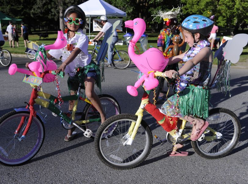 Amaya Martin, 9, left, Jacob Lawrence, 10, (in back) and Jose Lawrence, 7, spent the day decorating  themselves and their bikes in a slash of Hawaiian color for the Spokane Summer Parkways event on Wednesday night. The car-free event for walkers, bikers and other human powered transportation followed a loop between Manito and Comstock Parks on the South Hill. Spokane Summer Parkways is an idea inspired by an event in Bogota, Columbia called Ciclovia (meaning 