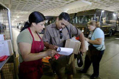 
Workers distribute packages at the Los Angeles hub of UPS, which on Tuesday reported a 4.1 percent rise in second-quarter earnings on a modest increase in sales. Associated Press
 (Associated Press / The Spokesman-Review)