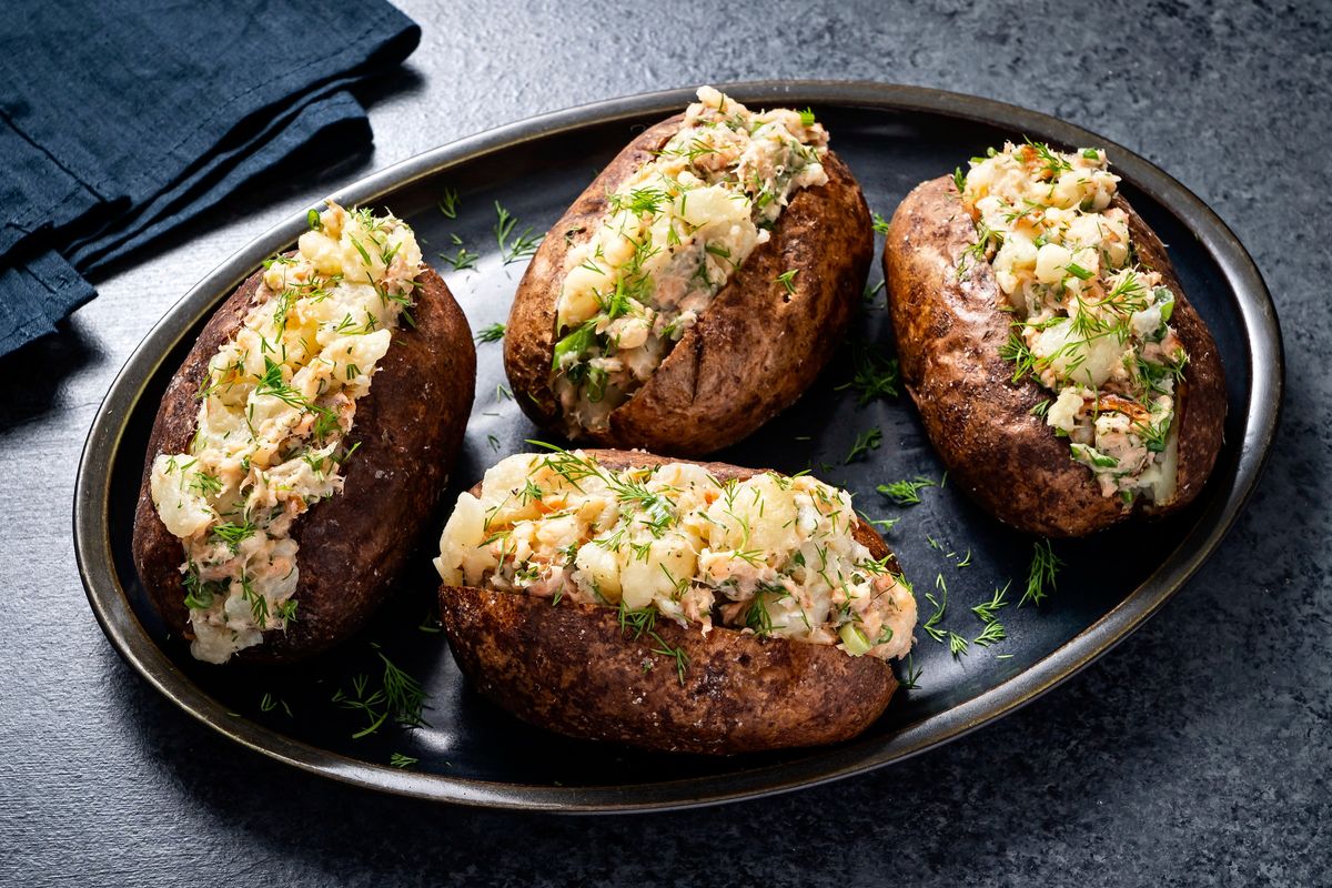 Baked potatoes flavored with compound butter that features smoked fish, fresh dill and scallions.  (Scott Suchman for The Washington Post)