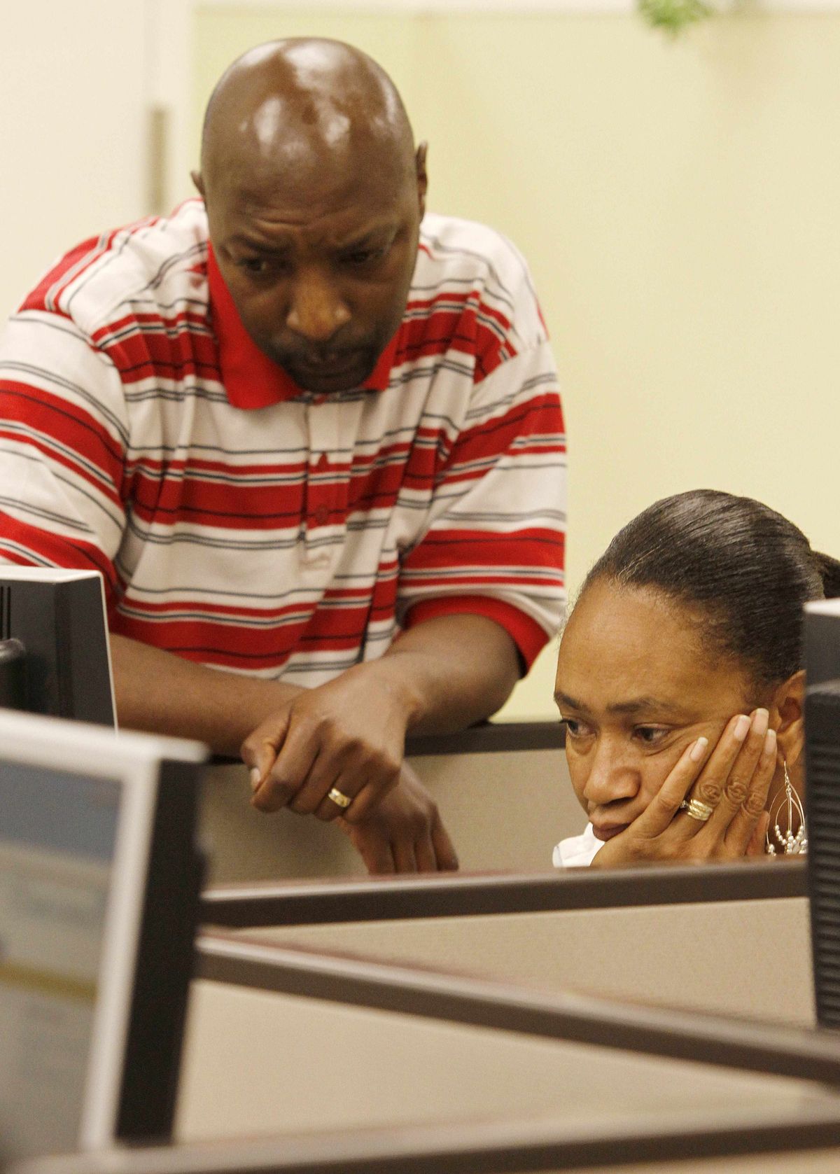 Mischelle Mitchell looks online for job listings with her husband, Raymond Alan, at the Oakland Career Center on Friday. 