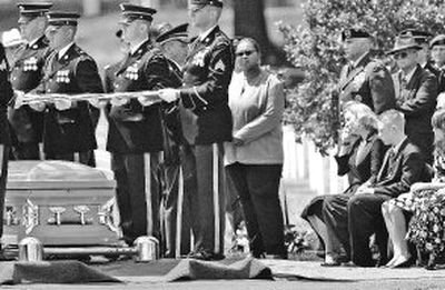 
With her son Aaron, 14, at her side, Cynthia Conner, seated at right, wife of Army Sgt. Maj. Bradly  Conner, cries as a military honor guard folds the American flag during burial services Thursday at Arlington National Cemetery in Arlington, Va.  Bradly Conner was killed in Iraq on May 9.
 (Associated Press photos / The Spokesman-Review)