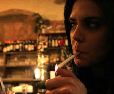 
A woman lights a cigarette in a bar in downtown Rome on Sunday. Smokers in Italy took their last puffs in smoky bars and trattorias Sunday before the start of one of Europe's toughest laws against smoking in public places.  
 (Associated Press / The Spokesman-Review)