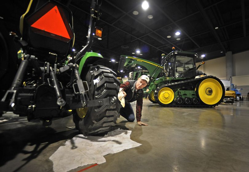 Dennis Solbrack, of Spokane’s Arrow Machinery, prepares John Deere equipment Monday for the Spokane Ag Expo and Pacific Northwest Farm Forum in the Group Health Pavilion of the Spokane Convention Center. (CHRISTOPHER ANDERSON)