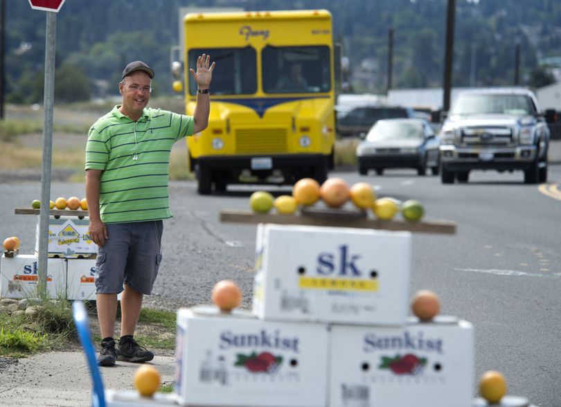 Ted Taylor waves to passing motorists from his fruit stand at 2900 E. Trent Ave., on Monday. (Dan Pelle)