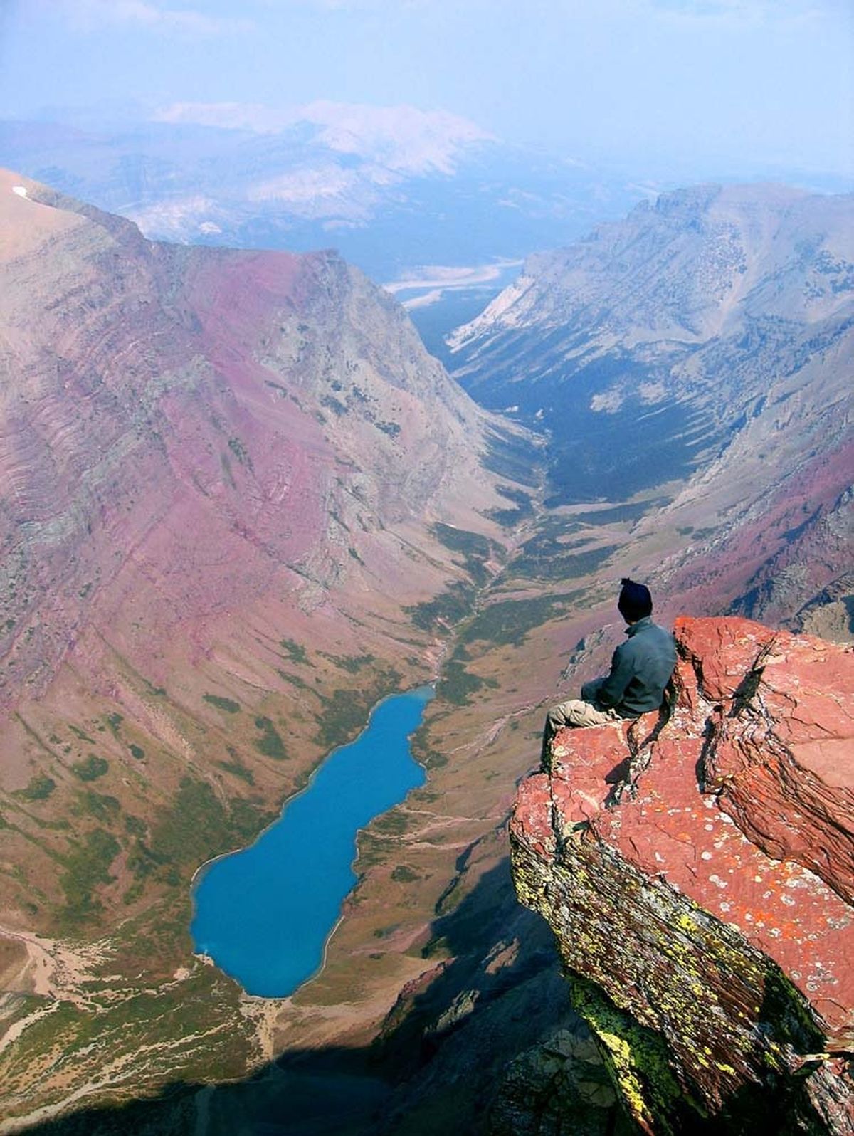 Jake Bramante sits atop the summit of Mount Siyeh overlooking Cracker Lake.